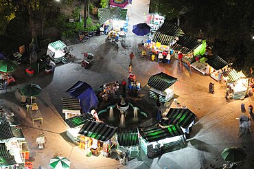 Mexico, Federal District, Mexico City, View onto Alameda park at night from Torre Latinoamericana with green and white striped roof awnings of street stalls below.