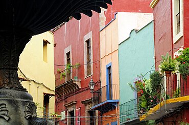 Mexico, Bajio, Guanajuato, Fountain detail in foreground of colourful buildings on Plaza del Baratillo.