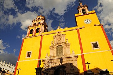 Mexico, Bajio, Guanajuato, Basilica de Nuestra Senora de Guanajuato or Basilica of Our Lady of Guanajuato. Baroque yellow painted exterior facade with clock and bell tower.