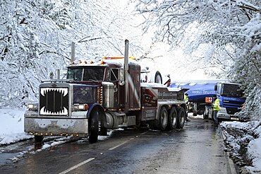 Weather, Winter, Snow, Recovery truck extracting a Jack-knifed fuel tanker on icy A22 main road near Nutley East Sussex after heavy snowfall.