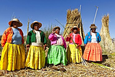 Peru, Puno, Lake Titicaca Women in colorful clothing on Grass Island.