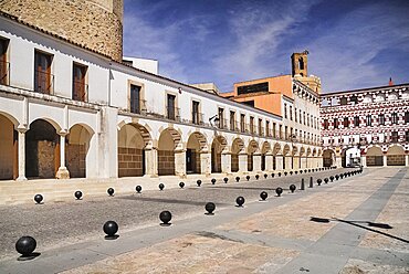 Spain, Extremadura, Badajoz, Colourfully painted buidlings in the Plaza Alta with Espantaperros tower behind.