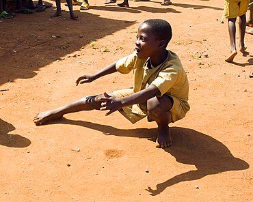 Burundi, Cibitoke Province, Buganda, Ruhagurika Primary School boys playing marbles during their playtime outside Ruhagurika Catch-Up Class. Catch up classes were established by Concern Worldwide across a number of schools in Cibitoke to provide a second chance for children who had dropped out.