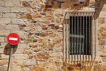 Spain, Extremadura, Caceres, No Entry sign against typical brick wall.