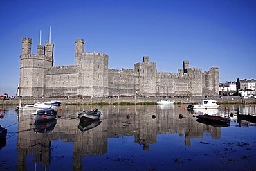 Wales, Gwynedd, Caernarfon, Caernarfon Castle Against Deep Blue Sky Overlooking The River Seiont as the tide comes in Construction Started In 1283 And Prince Charles Held His Investiture At The Castle In 1969. A UNESCO World