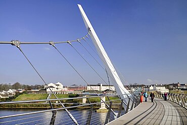 Ireland, North, Derry, The Peace Bridge over the River Foyle opened in 2011 with the former Ebrington Barracks in the background.