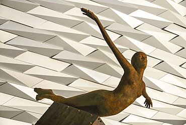 Ireland, North, Belfast, Titanic Quarter, Titanic Belfast Visitor Experience, 'Titanica' sculpture by Rowan Gillespie with section of the building in the background.