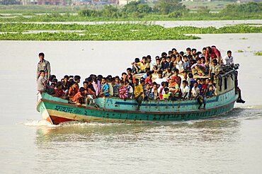 Bangladesh, Dhaka Division, Keraniganj Upazila, Overcrowded boat travelling down a tributary river.,