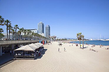 Spain, Catalonia, Barcelona, Barceloneta, Playa de St Sebastia, view along beach toward Port Olimpic.