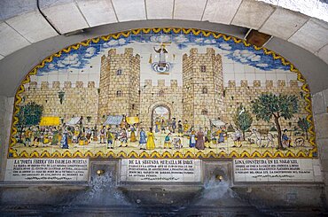 Spain, Catalonia, Barcelona, Drinking water fountain in Portaferrissa Street off La Rambla in the Gothic Quarter with a tiled depiction of one of the gates to the old walled city.,