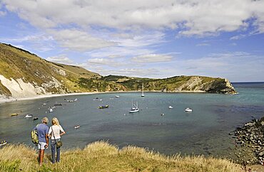 England, Dorset, Isle of Purbeck, Couple looking out over Lulworth Cove and Jurassic Coast.