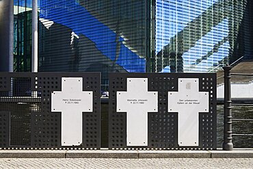 Germany, Berlin, Marie Elisabeth Luders Haus which is a service centre of the Bundestag located across the River Spree behind the Reichstag with memorial crosses to Berlin Wall victims in the foreground.