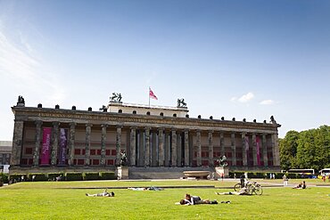 Germany, Berlin, Mitte, Museum Island, Altes Musuem exterior, with people sunbathing on the lawns in front.