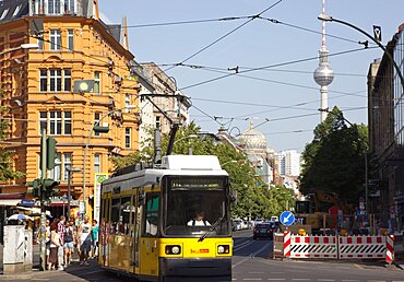 Germany, Berlin, Mitte, tram exiting Oranienburger Strasse with the Neue Synagogue and TV tower behind.