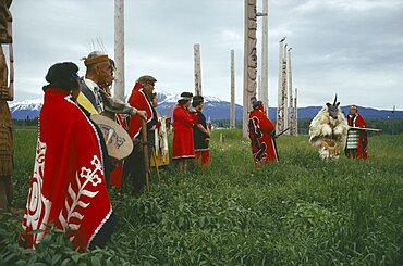 CANADA British Columbia  Native Indian Kwakiutl tribe totem poles with tribesmen and a dancer dressed as an animal deity