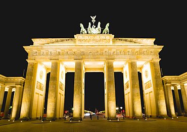 Germany, Berlin, Mitte, Brandenburg Gate or Brandenburger Tor in Pariser Platz illuminated at night leading to Unter den Linden and the Royal Palaces with the Quadriga of Victory on top. The only remaining of the original 18 gates in the Berlin Customs Wall.