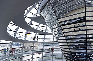 Germany, Berlin, Mitte, Tiergarten, interior of the glass dome on the top of the Reichstag building designed by architect Norman Foster with a double-helix spiral ramp around the mirrored cone that reflect light into the debating chamber of the Bundestag below.