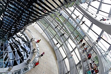 Germany, Berlin, Mitte, Tiergarten, interior of the glass dome on the top of the Reichstag building designed by architect Norman Foster with a double-helix spiral ramp around the mirrored cone that reflect light into the debating chamber of the Bundestag below.