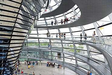 Germany, Berlin, Mitte, Tiergarten, interior of the glass dome on the top of the Reichstag building designed by architect Norman Foster with a double-helix spiral ramp around the mirrored cone that reflect light into the debating chamber of the Bundestag below.