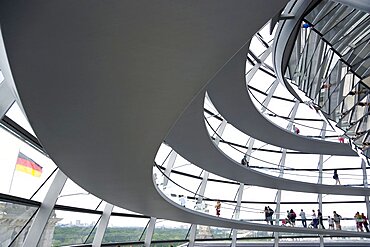 Germany, Berlin, Mitte, Tiergarten, interior of the glass dome on the top of the Reichstag building designed by architect Norman Foster with a double-helix spiral ramp around the mirrored cone that reflect light into the debating chamber of the Bundestag below.