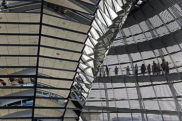 Germany, Berlin, Mitte, Tiergarten, interior of the glass dome on the top of the Reichstag building designed by architect Norman Foster with a double-helix spiral ramp around the mirrored cone that reflect light into the debating chamber of the Bundestag below.