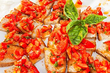 Italy, Tuscany, Lucca, Barga, Small slices of bread topped with tomato on display for a buffet.