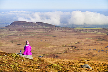 Ireland, County Fermanagh, Cuilcagh Mountain Park, Hiker enjoying the view from the summit of Cuilcagh Mountain.