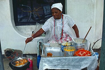 BRAZIL  Bahai Woman cooking on street stall serving traditional slave food.  Brasil