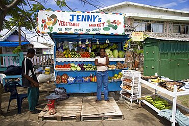 WEST INDIES St Vincent & The Grenadines Union Island Fruit and vegetable market stall with owner in Hugh Mulzac Square in Clifton