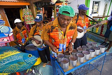 WEST INDIES St Vincent & The Grenadines Union Island Miniature steel drum pan player and band playing at a roadside bar during Easterval Easter Carnival in Clifton