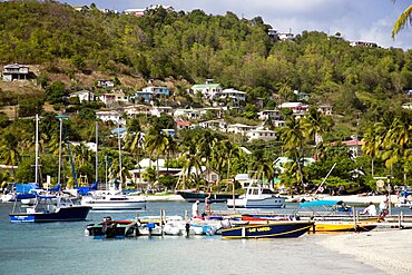 WEST INDIES St Vincent & The Grenadines Bequia Jetty with moored yachts in Admiralty Bay with hillside houses beyond in Port Elizabeth