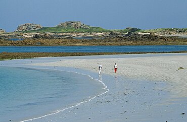 UNITED KINGDOM Channel Islands Guernsey Castel. Cobo Bay. View across sandy shoreline with people walking on sand.