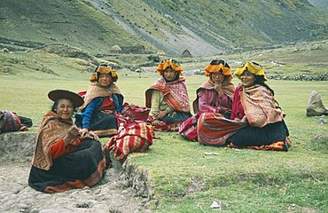 PERU Cusco Cancha Cancha Local Quechuan women sat on grass  wearing traditional dress.  Cuzco  Sacred Valley  Andes  Cuzco  Sacred Valley  Andes