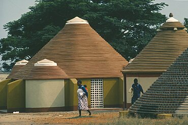 ANGOLA  Tradtional Homes Women and child outside new village housing.