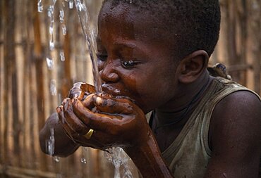 SIERRA LEONE  Water Child cupping his hands together drinking well water African Kids Western Africa Children