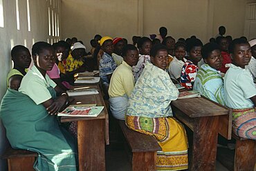 MALAWI  Kunyinda Camp Mozambican refugee women attending adult literacy class. Young woman in foreground with child asleep on her back.