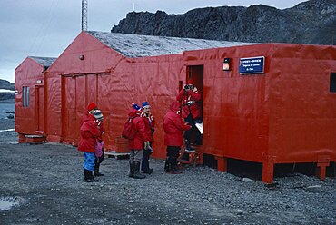 ANTARCTICA  King George Island Teniente Marsh Station. Tourists wearing red jackets outside Post Office