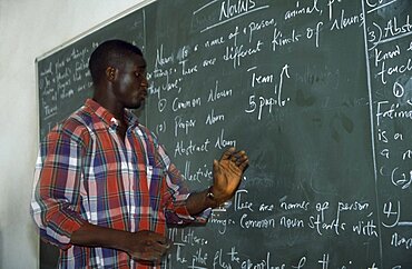 NIGERIA  Kano English teacher standing beside blackboard giving grammar lesson. African Learning Lessons Nigerian Teaching Western Africa