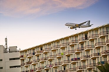 SPAIN Balaeric Islands Ibiza Eivissa. Charter flight coming into land at Ibiza airport  Aeroport dEivissa  with tourist hotel in the foreground. Jon Hicks. Tourism Holidays Mediterranean Balearic Islands Travel Leisure Spain Europe Eivissa Ibiza City Transport Aeroplane Flying Airplane Espainia Espana Espanha Espanya European Hispanic Southern Europe Spanish Gray Grey