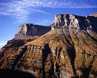 SPAIN Aragon Valle de Ordesa Eroded cliffs above Bosque de Las Hayas.  Grey rock scattered with trees and partly covered with brown / green vegetation.