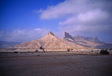 Desert landscape with triangular rock formation and pinnacles in sunlight, Howtah, Saudi Arabia