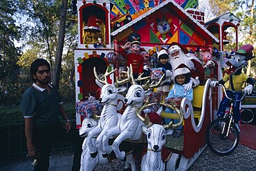 Children visiting Father Christmas in his sleigh in Mexico City Park, Mexico City, Mexico