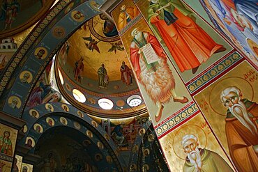 Nazareth, Interior of the Greek Orthodox Church of St, Gabriel also known as the Church of the Annunciation part view of domed roof and archways decorated with paintings of biblical scenes and the saints wall hangings and tiled mosaics, Church is located over the spring that fed Marys Well, Sea of Galilee, Hazafon, Israel