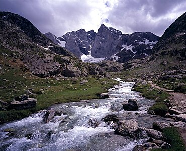 Upper Vallee de Gaube, Fast flowing river tumbling over rocks in mountain landscape with central peak and north face of Vignemale 3298 m high south of Pont d Espagne, Hautes-Pyrenees, Midi-Pyrenees, France