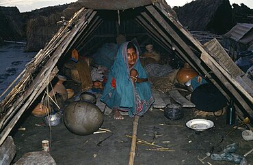 Flood victim and child in makeshift shelter, Asia