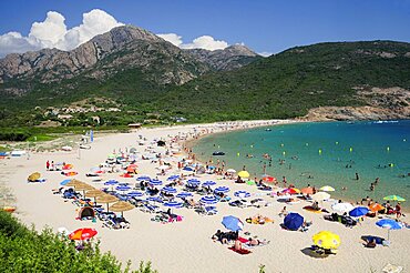 Plage Darone sandy beach with umbrellas & bathers & clear water, France