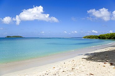 Waves breaking on Paradise Beach at LEsterre Bay with the turqoise sea and Sandy Island sand bar beyond, Caribbean