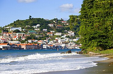 The hillside buildings and waterfront of the Carenage in the capital St Georges seen from Pandy Beach beside Port Louis Marina, Caribbean