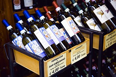 ITALY, Tuscany, San Gimignano, Bottles of Chianti and Vernaccia di San Gimignano wines displayed for sale outside a wine shop or enoteca with prices given in Euros