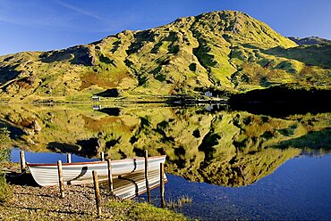 IRELAND, County Galway, Connemara, Kylemore Lough with moored rowing boat and Benbaun Mountain behind